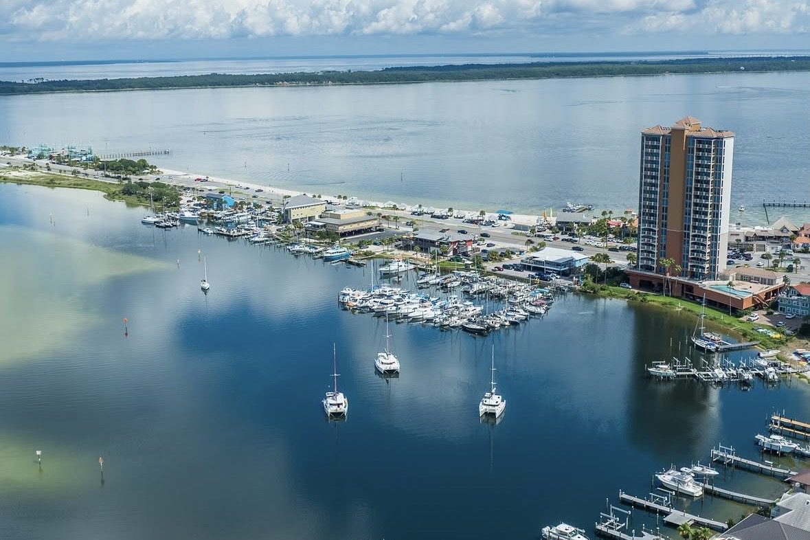 A marina and condominium tower on the water at Pensacola Beach