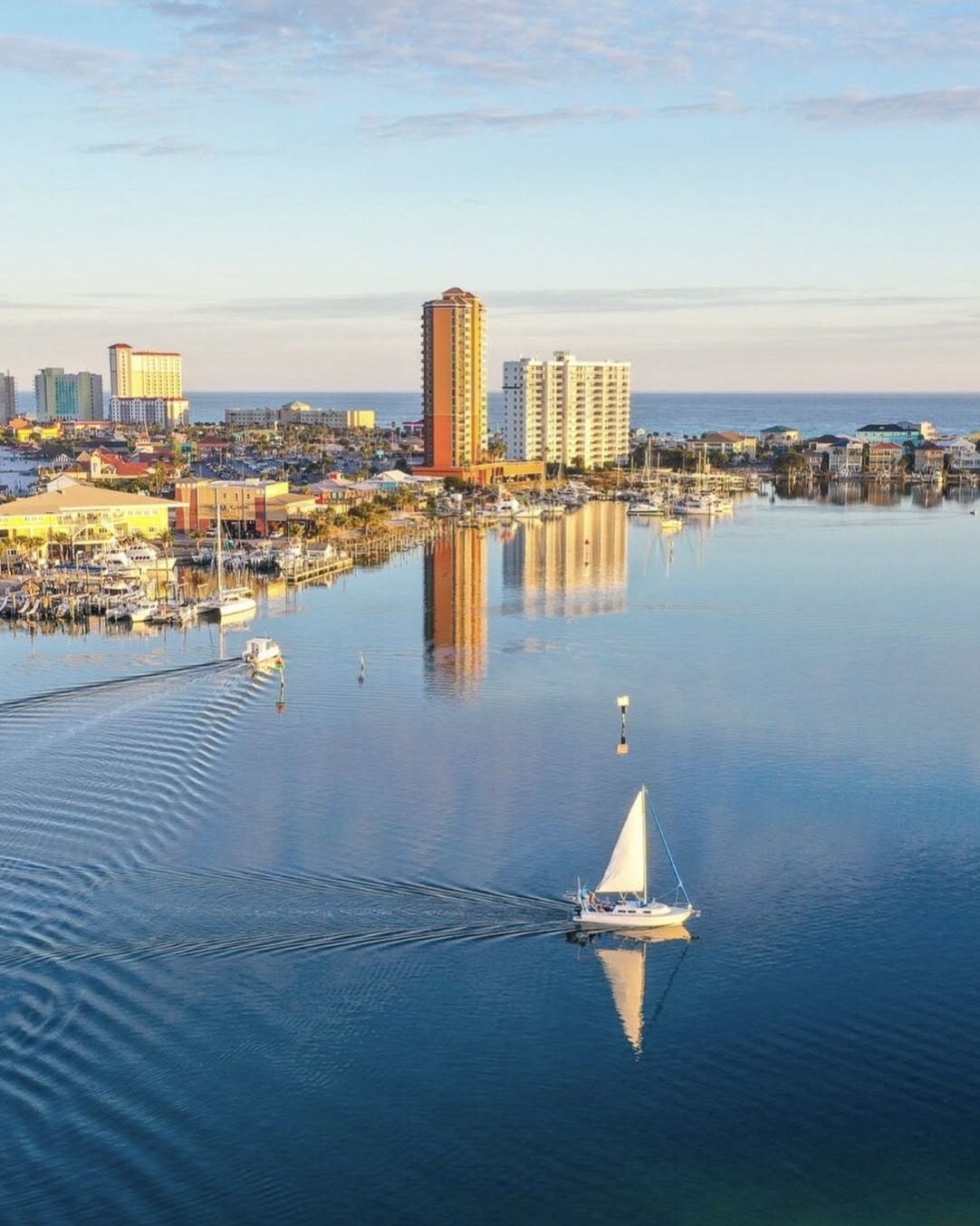 A sailboat crossing calm water near Pensacola Beach
